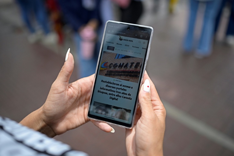 Une femme lit un article du site vénézuélien Caraota Digital à Caracas, le 17 septembre 2026