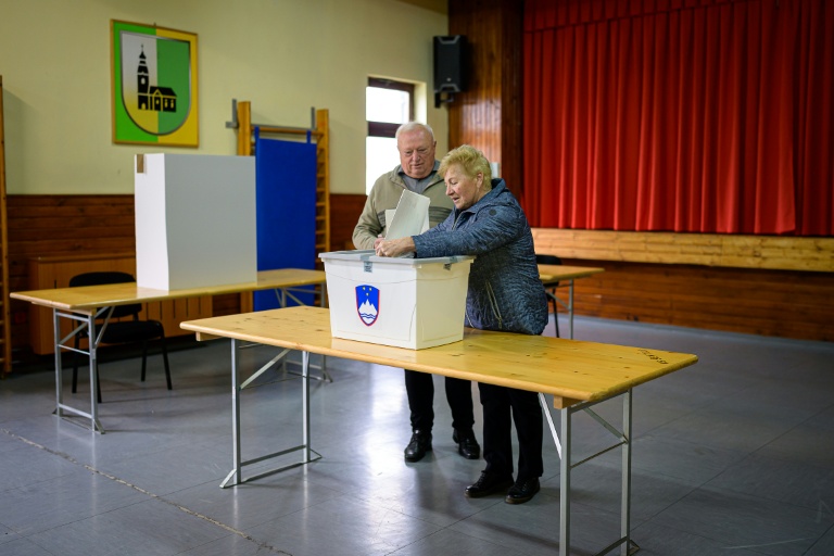 Un couple de personnes âgées vote aux élections législatives, le 22 mars 2026 à Arnace en Slovénie 