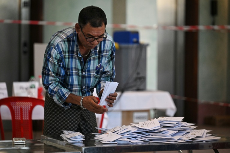 Un membre de la commission électorale birmane (UEC) trie des bulletins dans un bureau de vote de Rangoon, le 28 décembre 2025