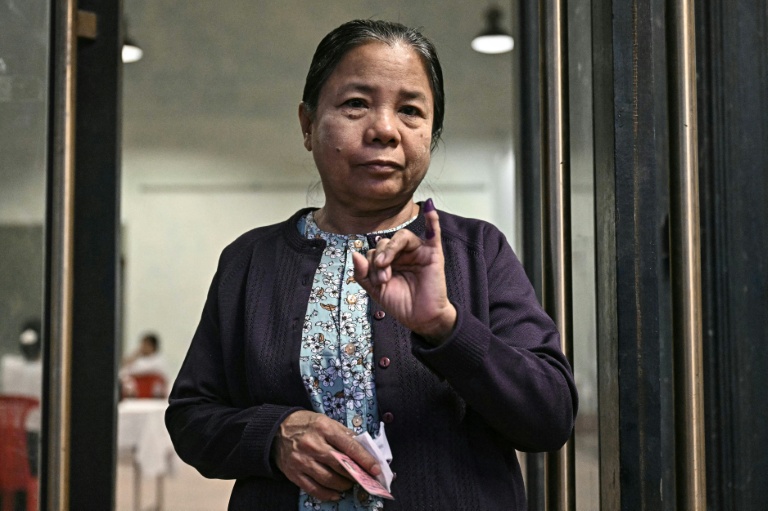 Une femme montre son doigt encré après avoir voté à Rangoun, le 28 décembre 2025