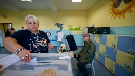 Une femme dépose son bulletin dans l'urne dans un bureau de vote lors des législatives à Sofia, le 19 avril 2026
