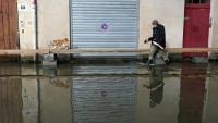 Un homme promène son chien dans une rue inondée d'Angers, le 20 février 2026 
