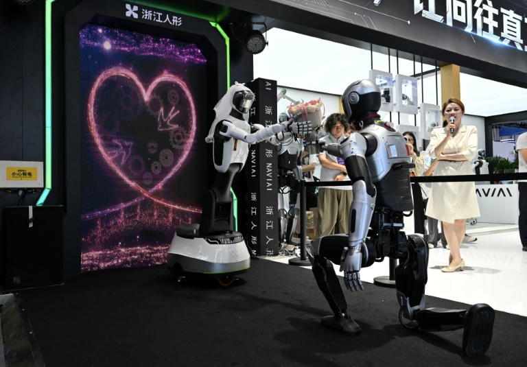 Les robots humanoïdes NaviAi i3 (d) et WA2 (g), produits par Zhejiang Humanoid Robot Innovation, célèbrent une cérémonie de mariage au salon mondial des robots à Pékin, le 19 août 2026