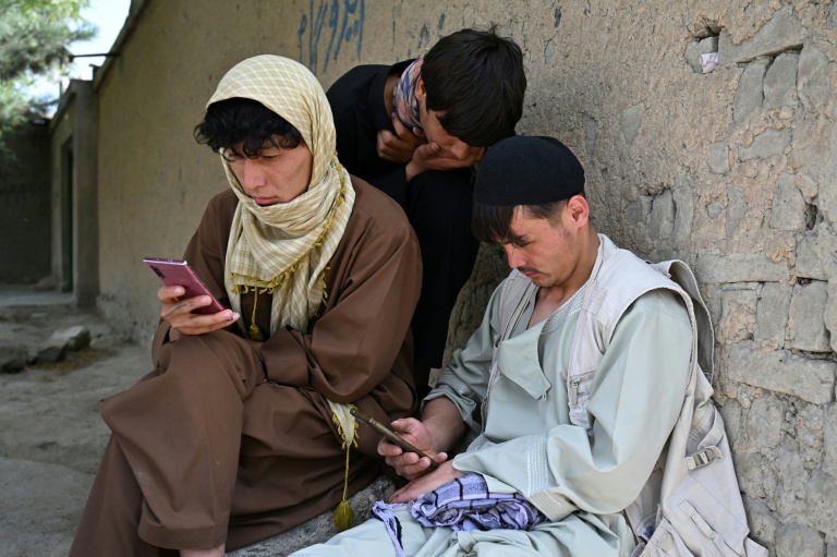Des jeunes Afghans consultent leurs smartphones à Kaboul, le 10 août 2026