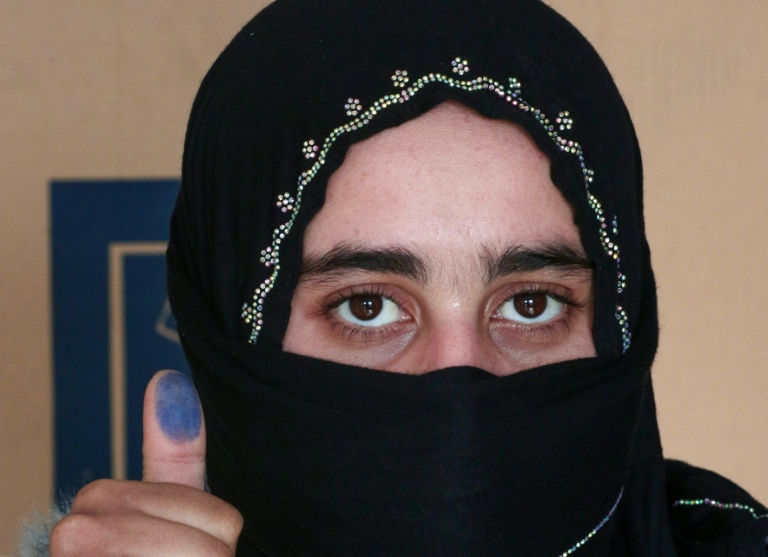 Une Irakienne déplacée montre son doigt taché d'encre après avoir voté dans un bureau de vote, avant les élections législatives du 11 novembre, dans un camp du nord de l'Irak, le 9 novembre 2025