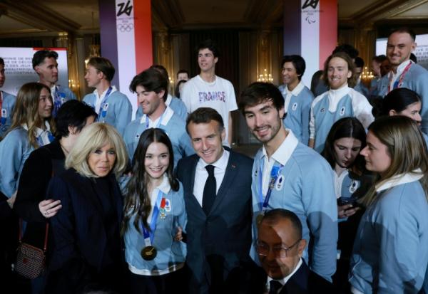 Le président Emmanuel Macron (c) et son épouse Brigitte Macron (g) avec les médaillés d'or en patinage artistique Laurence Fournier Baudry (2e g) et Guillaume Cizeron (d), lors d'une cérémonie de remise de médailles en l'honneur des athlètes français ayant participé aux Jeux olympiques d'hiver de Milan-Cortina 2026 à l'Élysée, le 29 avril 2026 à Paris