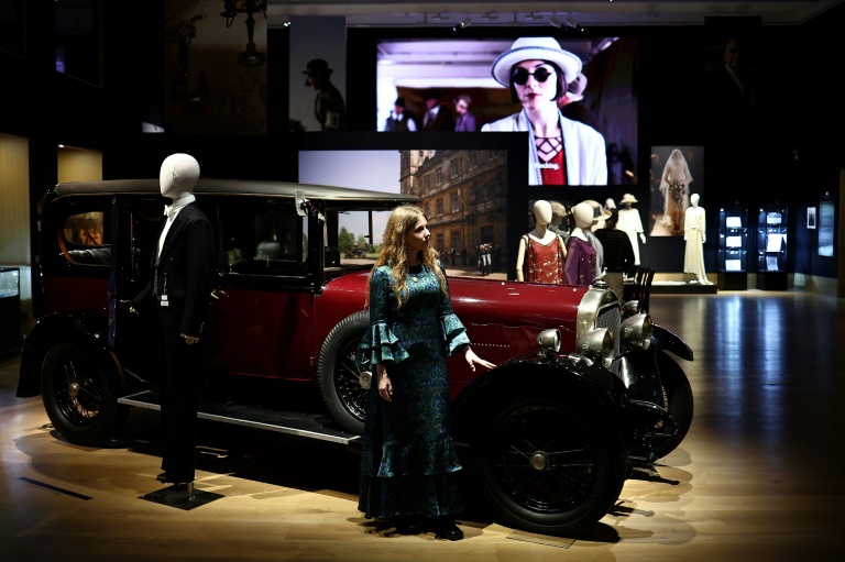 Une employée de la maison de vente aux enchères devant berline Sunbeam de 1925 utilisée dans la série britannique Downton Abbey lors d'une exposition d'accessoires, de costumes et d'autres objets de la franchise avant leur mise aux enchères, le 8 août 2025 à Londres