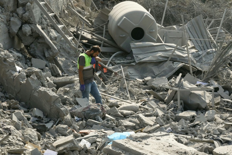 Les premiers secours cherchent des survivants dans les décombres d'une maison du village d'Ansar, au sud du Liban, frappée par l'armée israélienne le 15 août 2026. 