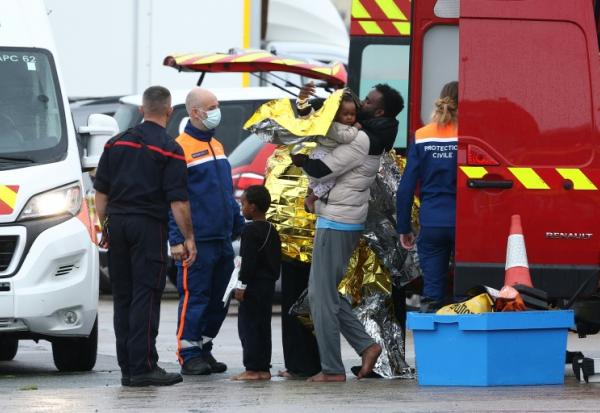Des rescapés revêtent  des couvertures de survie  à la suite du naufrage de leur canot transportant des migrants qui tentaient de traverser la Manche depuis la France vers le Royaume-Uni, à Calais, dans le nord de la France, le 28 septembre 2026