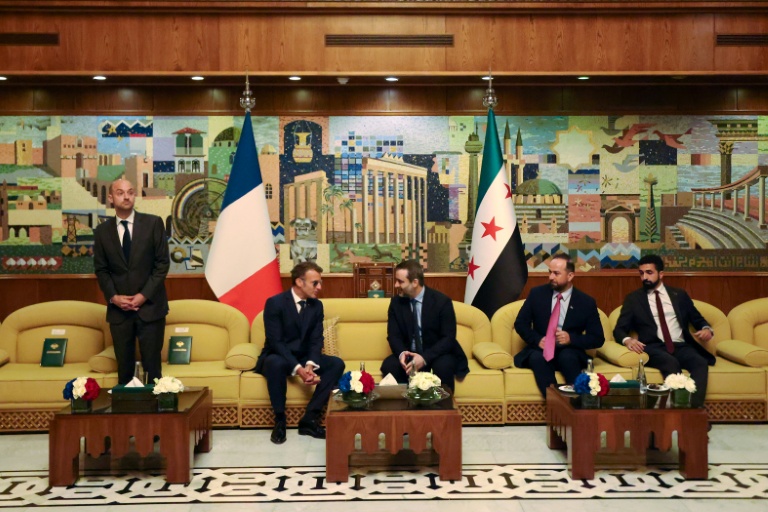 Le président français Emmanuel Macron (2e g) s'entretient avec le ministre syrien des Affaires étrangères Assaad al-Chaibani (c,d), aux côtés du ministre français des Affaires étrangères Jean-Noël Barrot (g), lors d'une rencontre bilatérale à l'aéroport international de Damas, le 6 juillet 2026 en Syrie