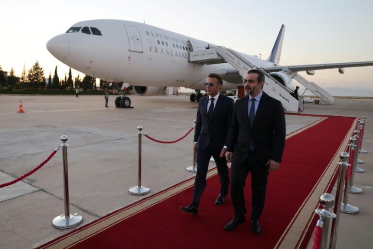 Le président français Emmanuel Macron (g) est accueilli par le ministre syrien des Affaires étrangères Assaad al-Chaibani (d) à son arrivée à l'aéroport international de Damas, pour une visite d'État, le 6 juillet 2026 en Syrie