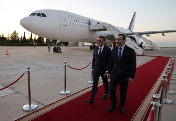 Le président français Emmanuel Macron (g) est accueilli par le ministre syrien des Affaires étrangères Assaad al-Chaibani (d) à son arrivée à l'aéroport international de Damas, pour une visite d'État, le 6 juillet 2026 en Syrie
