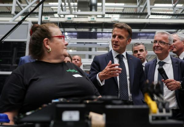 Le président Emmanuel Macron (d) parle avec une employé elors de sa visite de l'usine Vorwerk, dans le cadre du sommet "Choose France", à Donnemain-Saint-Mames, le 29 mai 2026 dans le Loir-et-Cher