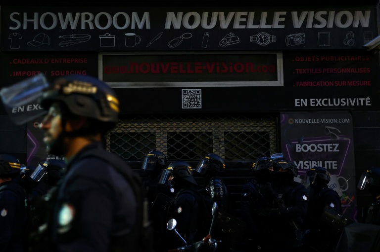 Des policiers antiémeutes devant un magasin équipé d'un rideau de fer lors d'une manifestation, le 24 octobre 2026 à Marseille
