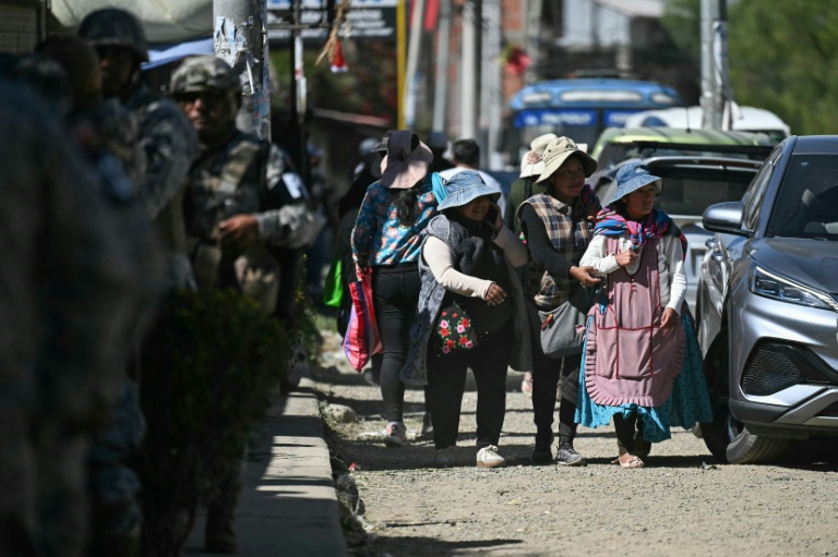 Des personnes empruntent une route après sa réouverture, auparavant bloquée par des manifestants exigeant la démission du président Rodrigo Paz,  le 5 juin 2026 à Carreras, dans le département de La Paz, en Bolivie