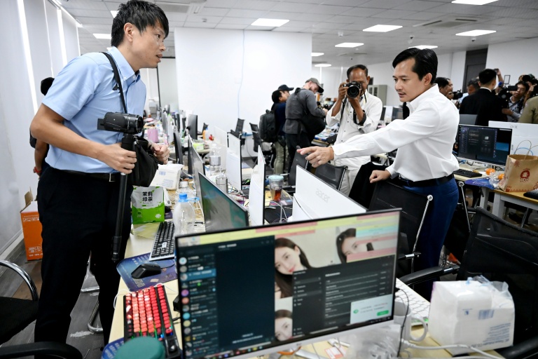 Tep Asnarith, à droite, sous-secrétaire d’État cambodgien et porte-parole du ministère de l’Information, regarde des messages sur un écran saisi dans un centre d’opérations d’arnaques en ligne, à Phnom Penh, le 11 mars 2026, au Cambodge 