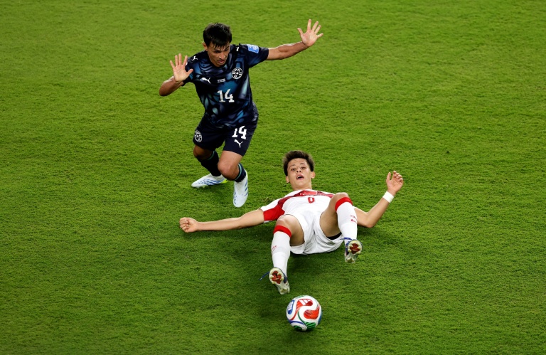 Arda Güler (au sol), le milieu offensif de la Turquie, face à Andres Cubas, le milieu défensif du Paraguay, lors d'un match du groupe D de la Coupe du monde 2026 opposant la Turquie au Paraguay, à Santa Clara, le 19 juin 2026