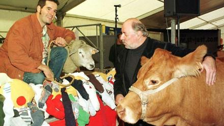 Philippe Soulas (D) tient la vache qu'il s'est vu offrir par le cou, le 09 octobre 1999, après avoir remporté le prix de l'humour vache au 18e Salon International de dessin de presse et d'humour de Saint-Just-Le-Martel (Haute-Vienne). Ivan Sigg, proclamé vainqueur du prix de l'humour tendre a reçu un agneau du Limousin.     