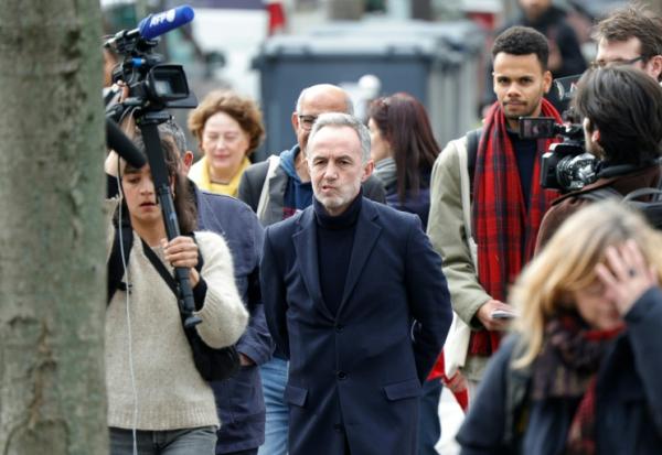 Emmanuel Grégoire (c), candidat socialiste (PS) à la mairie de Paris, entouré par des journalistes, déambule dans le quartier des Olympiades à Paris, dans le cadre de sa campagne électorale au lendemain du 1er tour des municipales
