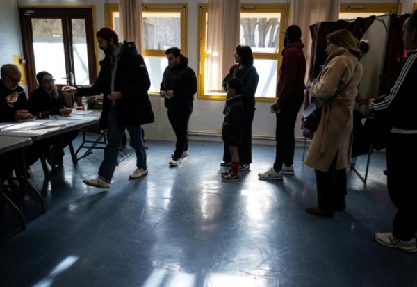 Des électeurs arrivent pour voter au 1er tour des municipales à Toulouse, le 15 mars 2026