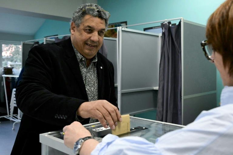 Le candidat indépendant à la mairie de Biarritz, Serge Blanco (c) vote au 2e tour des municipales, le 22 mars 2026 à Biarritz, dans les Pyrénées-Atlantiques