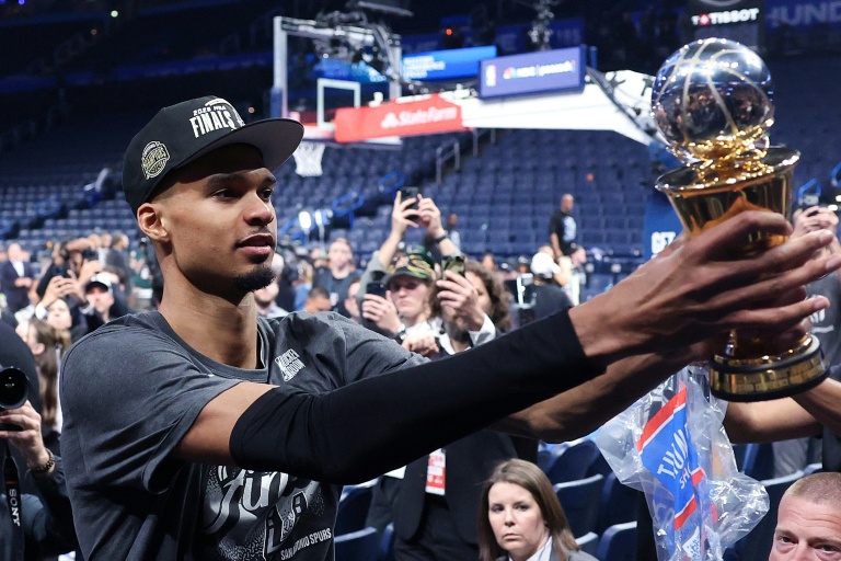Le basketteur Victor Wembanyama des San Antonio Spurs montre aux supporters son trophée après avoir été nommé MVP de la finale de Conférence ouest et avoir battu les Oklahoma City Thunder, le 30 mai 2026 à Oklahoma City, aux Etats-Unis