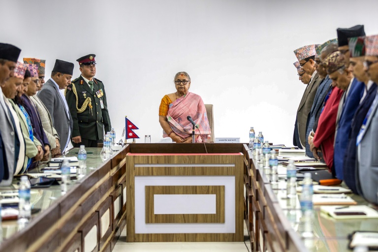 La nouvelle Première ministre du Népal Sushila Karki (C) lors d'une minute de silence observée en mémoire des victimes des émeutes meurtrières à Katmandou qui ont fait au moins 72 morts, le 14 septembre 2025 à Katmandou