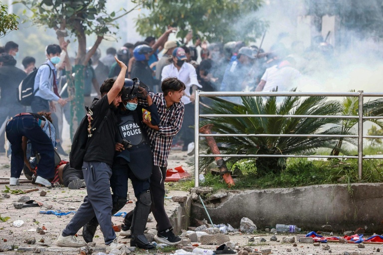 Un policier blessé est porté par des manifestants lors de heurts avec la police, le 8 septembre 2025 à Katmandou, au Népal