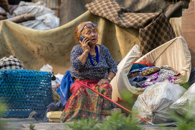 Une femme au téléphone lors de la démolition ordonnée par les autorités des bidonvilles abritant des milliers de personnes le long des berges de la capitale népalaise Katmandou, le 25 avril 2026