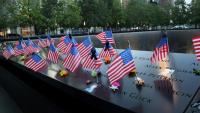 Des drapeaux américains placés sur le mur du bassin de la tour sud du Mémorial national du 11 septembre, au complexe du World Trade Center, le 11 septembre 2025, avant le début des cérémonies marquant le 24e anniversaire des attentats terroristes du 11 septembre 2001, à New York