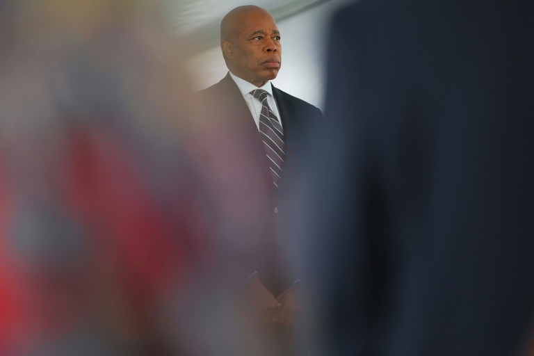 Le maire de New York, Eric Adams, se tient debout pendant la prière d'ouverture lors de l'inauguration du mur commémoratif du World Trade Center au siège des pompiers de New York, le 9 septembre 2025