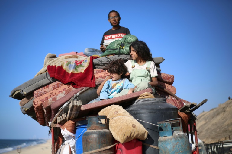 Des Palestiniens déplacés partent avec leurs biens vers le sud sur une route dans la zone du camp de réfugiés de Nousseirat, dans le centre de la bande de Gaza, après de nouveaux ordres d'évacuation israéliens pour la ville de Gaza le 16 septembre 2025