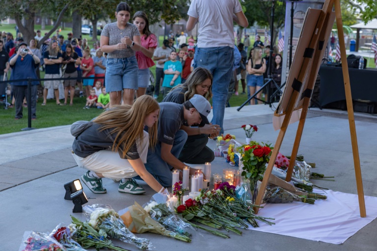 Des personnes déposent des fleurs en hommage à l'influenceur conservateur Charlie Kirk lors d'une veillée dans un mémorial improvisé à Orem, le 11 septembre 2025 dans l'Utah