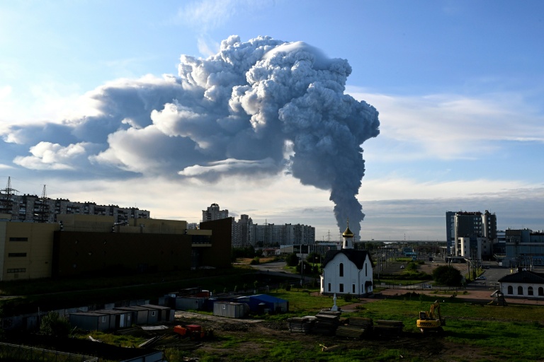 De la fumée s'élève au-dessus de batiments résidentiels depuis un entrepot de Wildberries près de Saint-Pétersbourg en Russie frappé par des drones ukrainiens le 24 juillet 2026