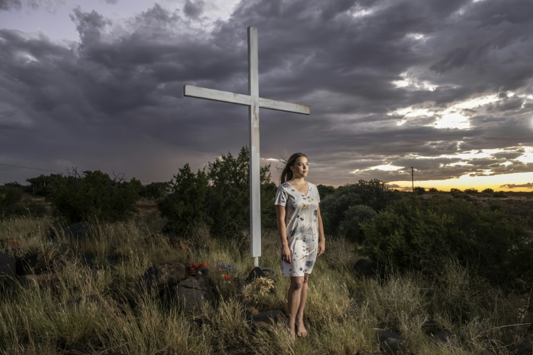 Doret Le Cornu, 23 ans et ayant emménagé il y a trois ans à Orania pose devant une croix dans cette enclave afrikaner de la province du Cap septentrional en Afrique du Sud, le 29 janvier 2026.