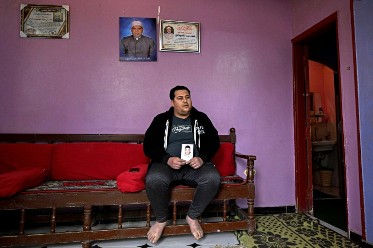Youssef Ibrahim montre un portrait de son frère Hamdy Ibrahim, 18 ans, disparu en Méditerranée, lors d'une interview dans le village d'Abdallah Aziza, en Egypte, le 21 janvier 2026