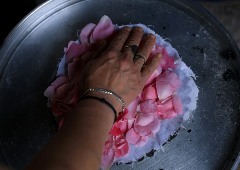 Ariana Nikolla prépare de l'eau de rose de manière traditionnelle à Përmet, le 28 mai 2025 en Albanie