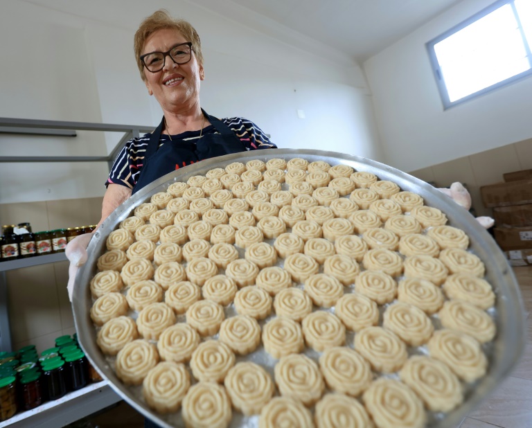 Eftali Qerimi montre un plateau de loukoums d'amande à l'eau de rose dans son atelier à Përmet, le 28 mai 2025 en Albanie
