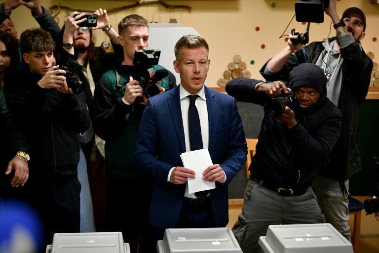 Peter Magyar (c), chef du parti conservateur pro-européen Tisza s'apprête à voter à Budapest, lors des législatives en Hongrie, le 12 avril 2026