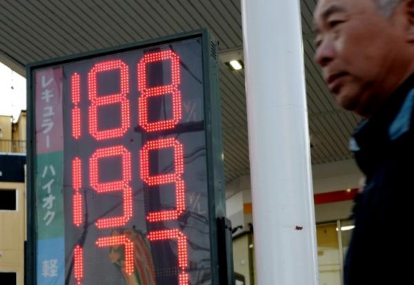 Une station-service japonaise affiche le prix de l'essence, qui a grimpé à 188 yens le litre pour l'essence ordinaire, à Tokyo, le 14 mars 2026