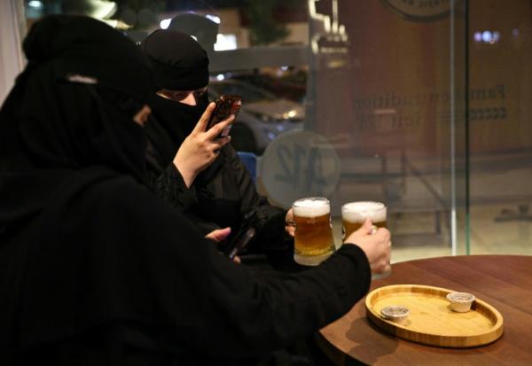 Deux femmes prennent en photo leur bière sans alcool à Ryad, Arabie saoudite, le 24 octobre 2025