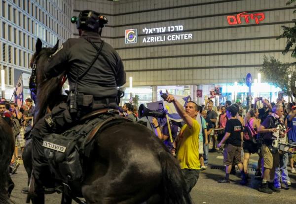 Confrontation entre un policier monté et un manifestant, lors d'une manifestation à Tel-Aviv pour réclamer un accord de cessez-le-feu à Gaza et le retour des otages du 7-Octobre, le 9 août 2025