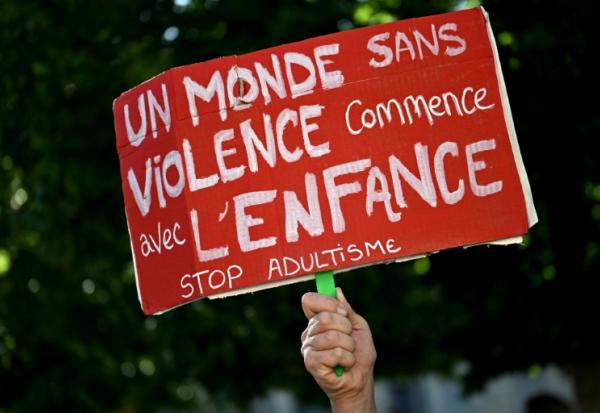 Un manifestant tient une pancarte contre les violences faites aux enfants lors d'une manifestation à Bordeaux le 15 juin 2026 après le décès de Lyhanna