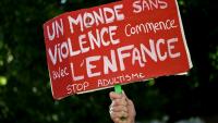Un manifestant tient une pancarte contre les violences faites aux enfants lors d'une manifestation à Bordeaux le 15 juin 2026 après le décès de Lyhanna