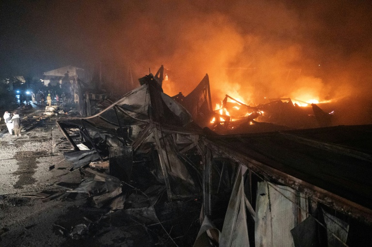 Des pompiers et des membres des forces de sécurité talibanes sur le site d'un hôpital pour toxicomanes détruit par des frappes aériennes pakistanaises, le 16 mars 2026 à Kaboul, en Afghanistan
