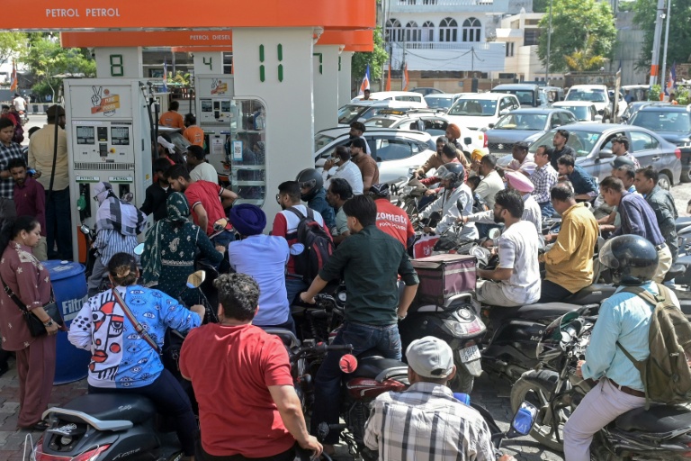 Des personnes se précipitent pour faire le plein de leur véhicule dans une station-service à Amritsar, le 27 mars 2026, en Inde
