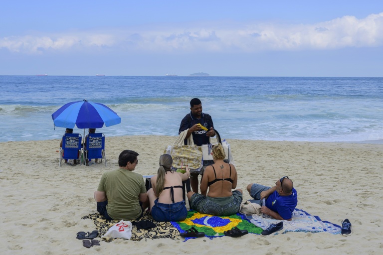 Un vendeur reçoit un paiement via le système de paiement instantané brésilien PIX sur la plage de Copacabana, à Rio de Janeiro, le 9 juillet 2026 au Brésil