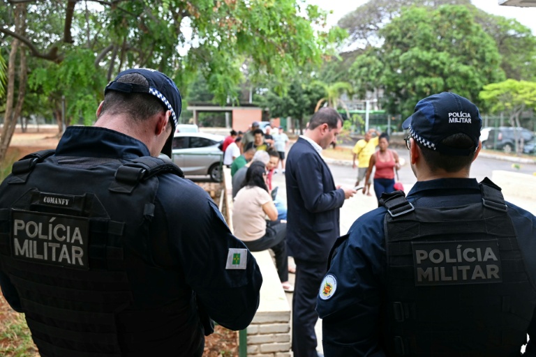 Des membres de la police militaire gardent l'entrée d'un bureau de vote lors du premier tour de la présidentielle au Brésil, le 4 octobre 2026 à Brasilia