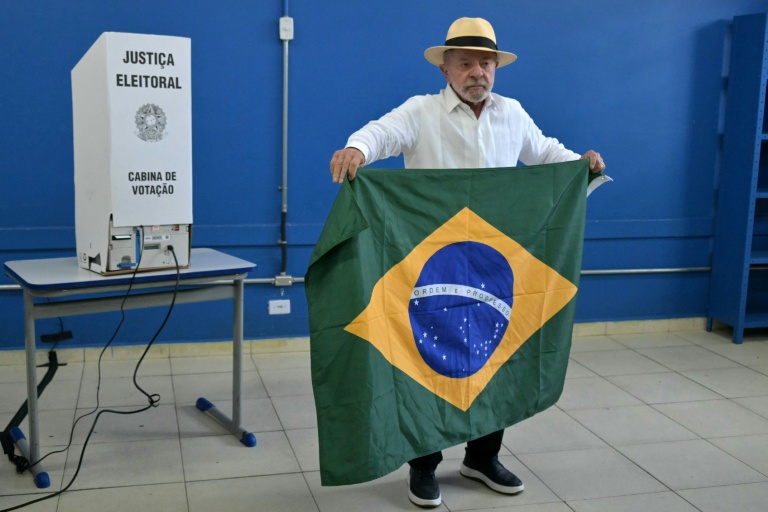 Le président brésilien de gauche, Luiz Inacio Lula da Silva, déploie le drapeau national dans le bureau où il vote au premier tour de la présidentielle à Sao Bernardo do Campo, dans l'Etat de Sao Paulo, le 4 octobre 2026  