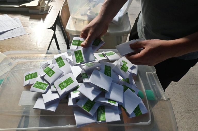 Un homme compte les bulletins dans un bureau de vote lors des élections générales, à Santiago, le 16 novembre 2025
